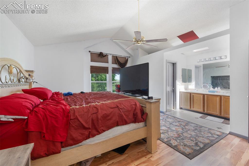 Image 40 of 50: Bedroom with lofted ceiling, wood finished floors, a textured ceiling, conn