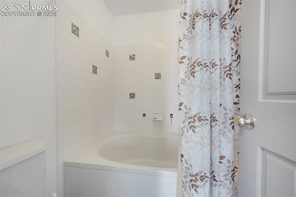 Image 42 of 50: Bathroom featuring toilet and shower / bath combo