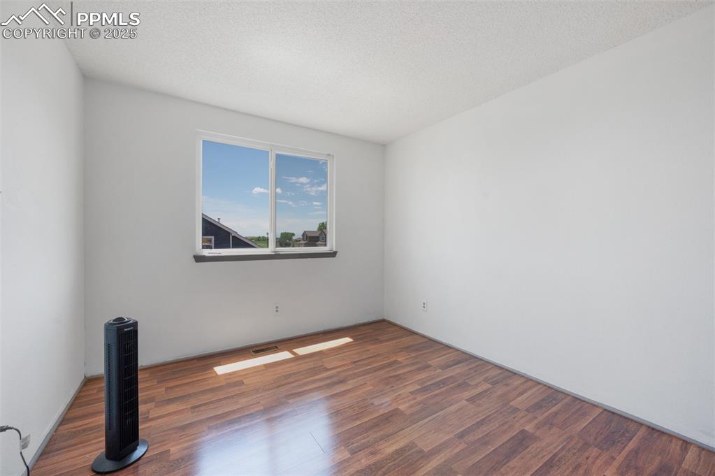 Image 43 of 50: Spare room featuring wood finished floors