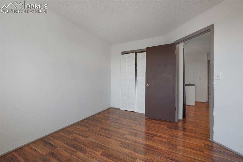 Image 45 of 50: Unfurnished bedroom featuring wood finished floors and a closet