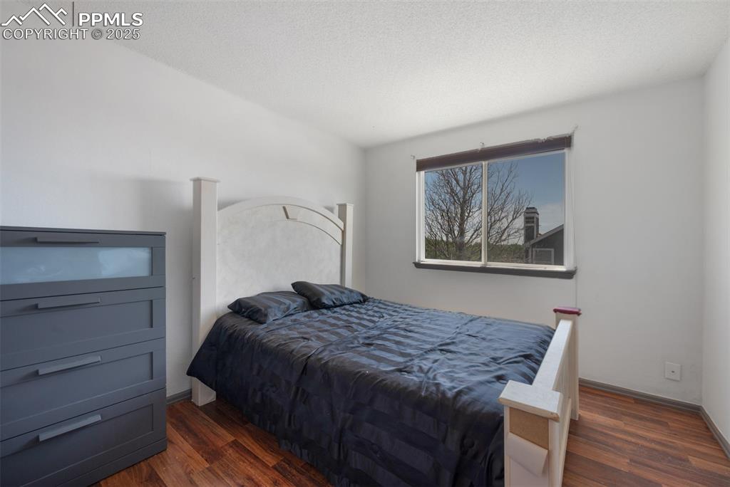 Image 46 of 50: Bedroom with dark wood-style flooring