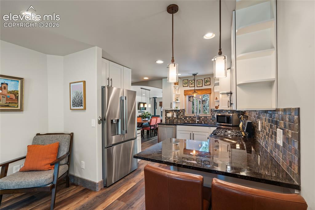 Image 8 of 38: Main house Kitchen with stainless appliances and granite counter tops.