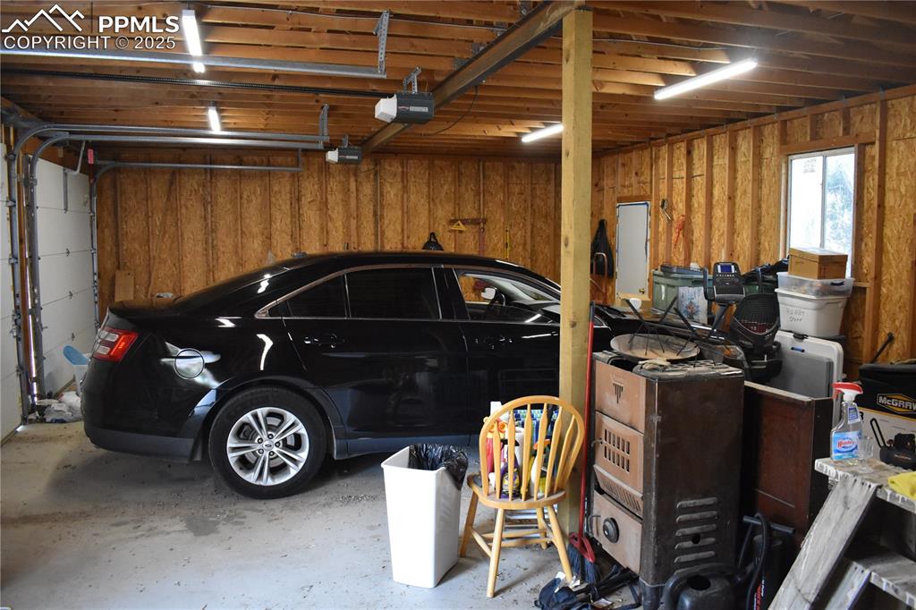 Image 14 of 47: Garage featuring wooden walls and a garage door opener