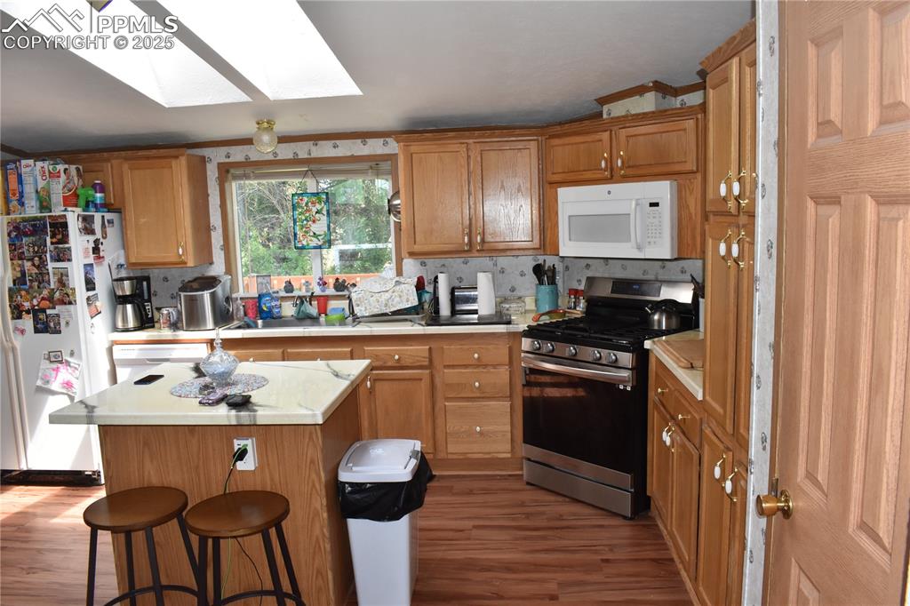 Image 29 of 47: Kitchen with light countertops, white appliances, dark wood-type flooring, 