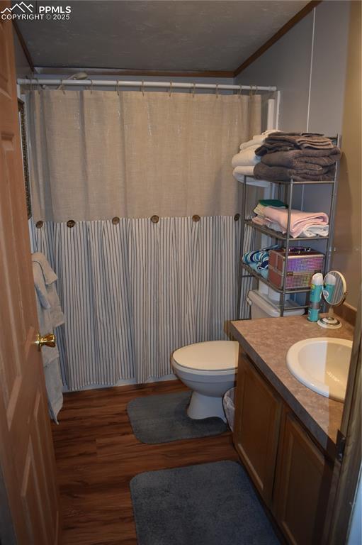 Image 30 of 47: Full bathroom featuring vanity, dark wood finished floors, crown molding, a