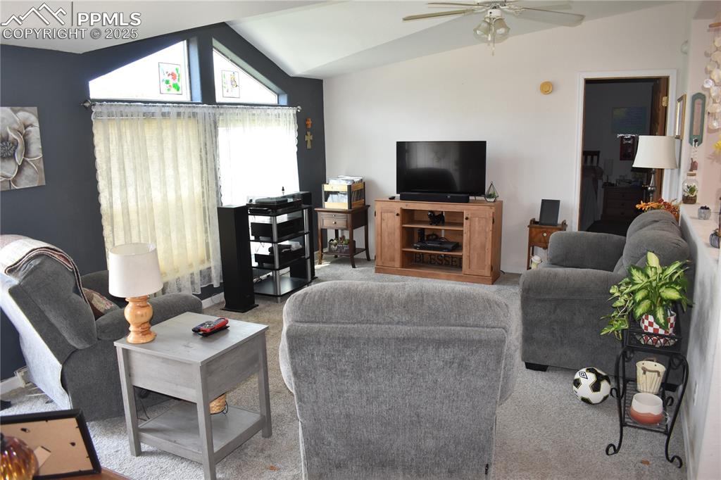 Image 38 of 47: Living room featuring lofted ceiling, carpet flooring, and ceiling fan