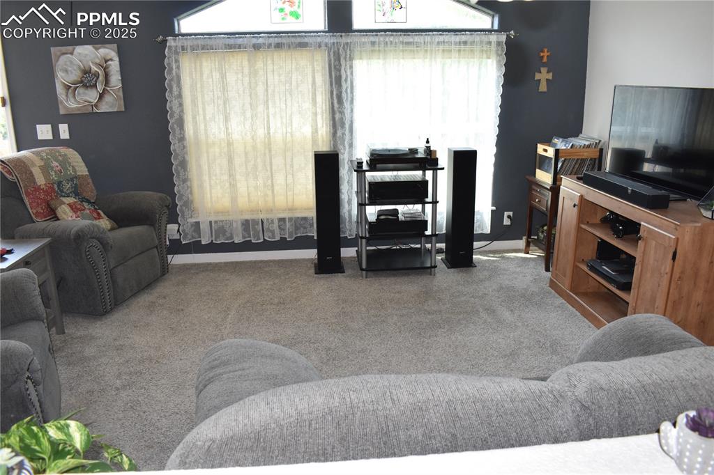 Image 40 of 47: Living room with light colored carpet and baseboards