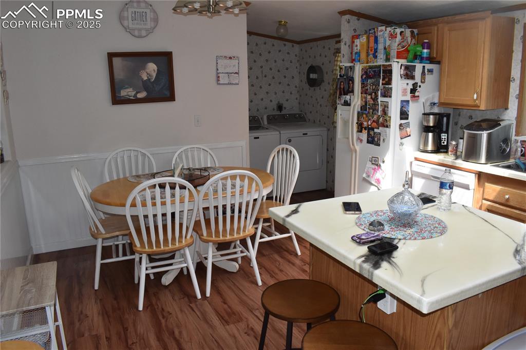 Image 42 of 47: Kitchen featuring light countertops, white appliances, a breakfast bar area