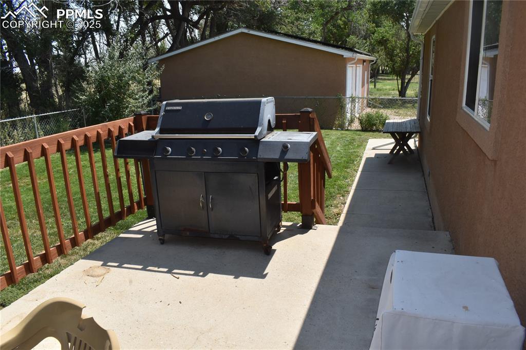 Image 43 of 47: View of patio / terrace featuring grilling area and view of wooded area