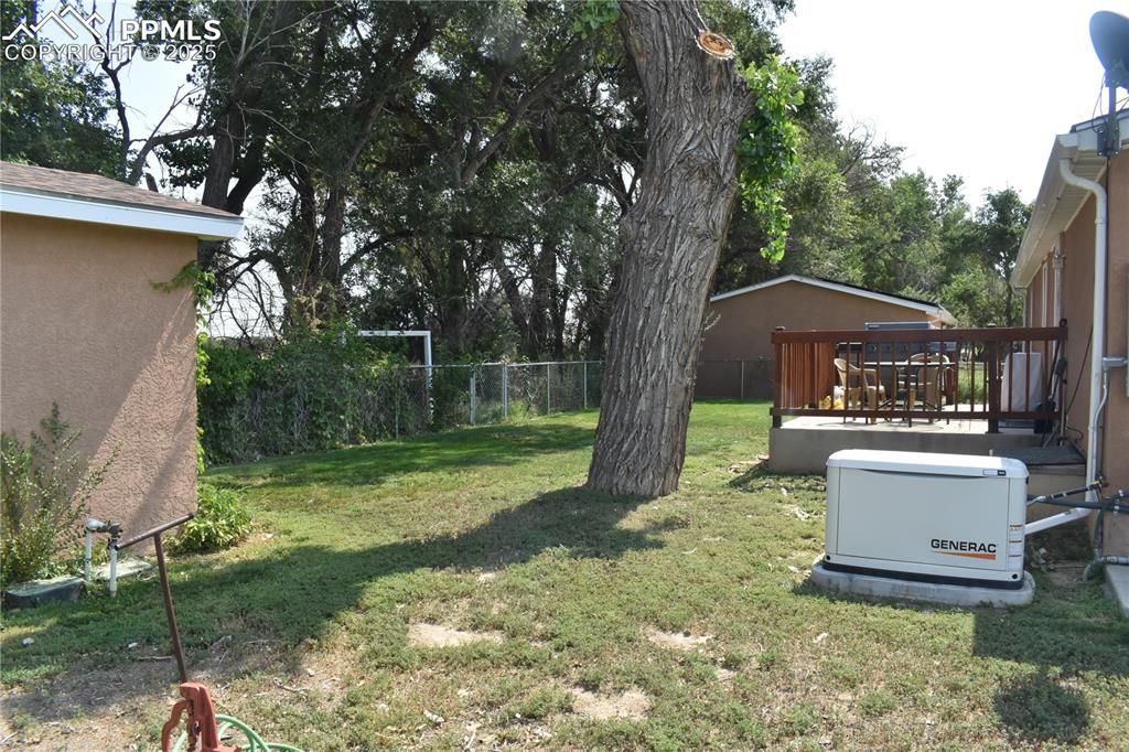 Image 5 of 47: View of yard with a deck and lawncare items
