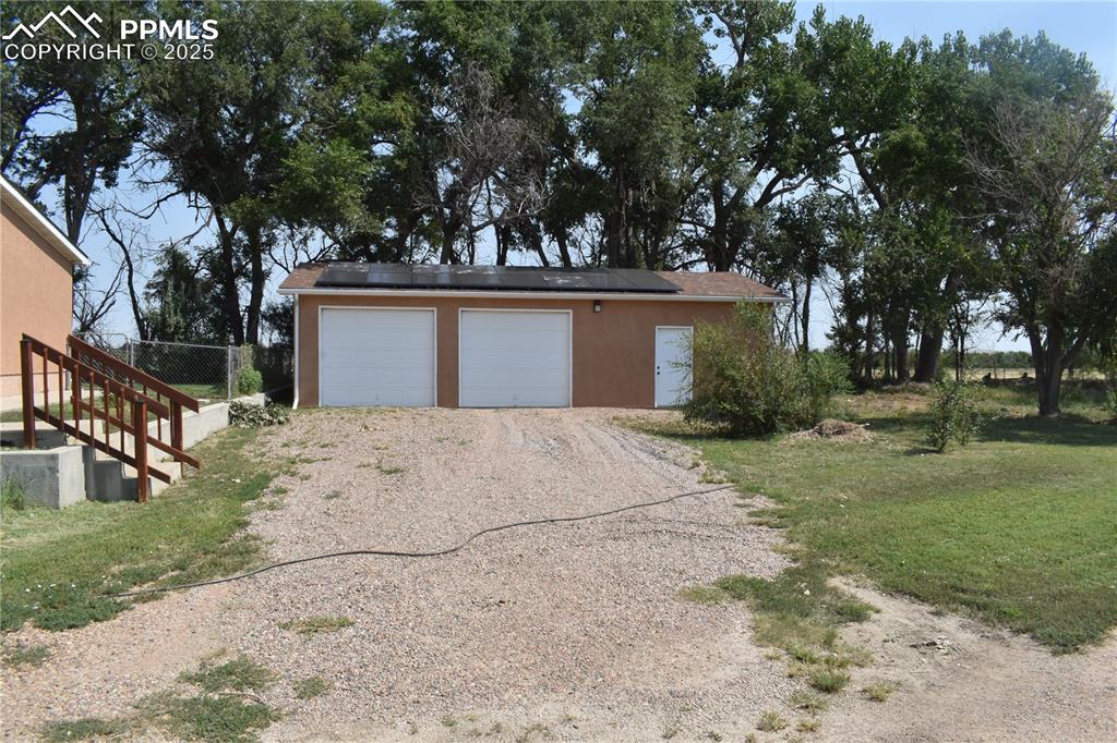 Image 7 of 47: Garage featuring solar panels and driveway
