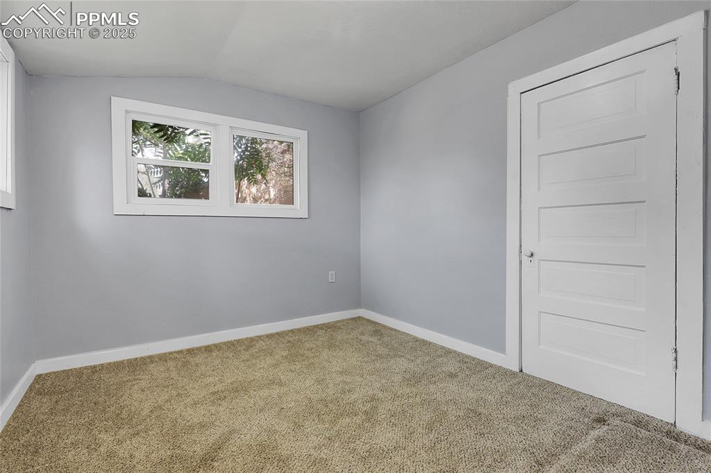 Image 23 of 29: Carpeted spare room with baseboards and vaulted ceiling