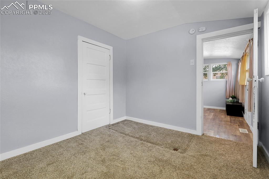 Image 24 of 29: Spare room with carpet flooring and vaulted ceiling
