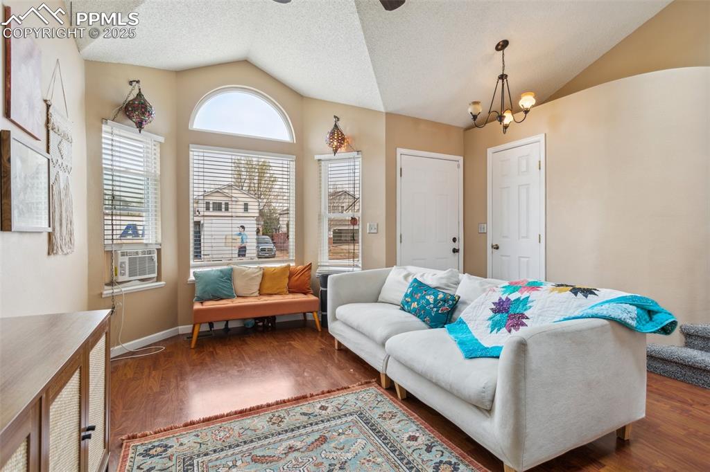 Image 11 of 35: Sitting room featuring ceiling fan with notable chandelier, wood finished f