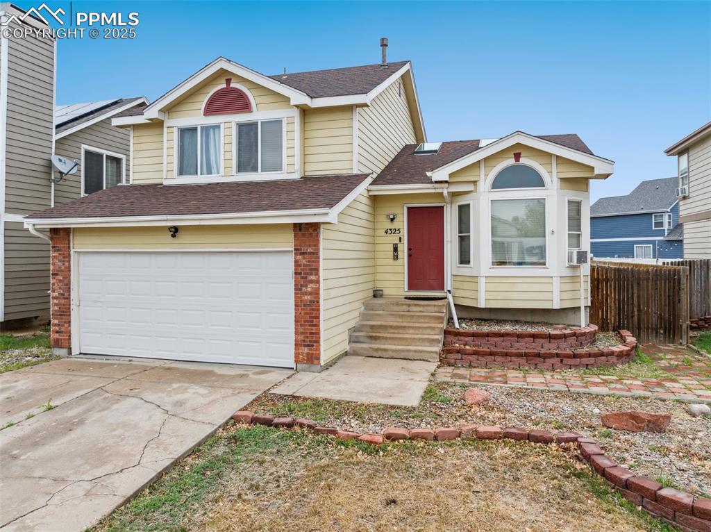 Image 2 of 35: Tri-level home featuring fence, roof with shingles, an attached garage, ent