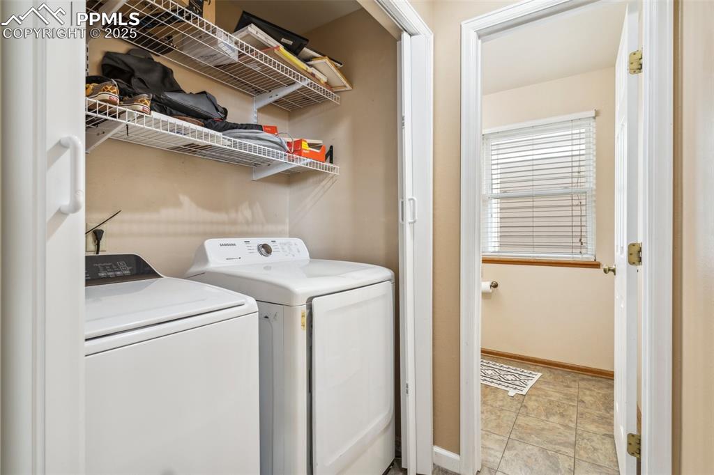 Image 20 of 35: Laundry room with laundry area, baseboards, washer and dryer, and stone fin