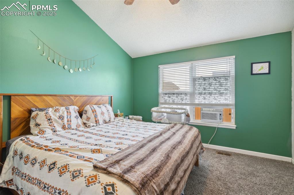 Image 21 of 35: Bedroom with ceiling fan, cooling unit, a textured ceiling, carpet, and lof