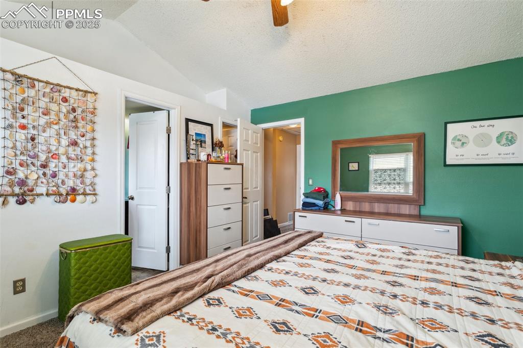 Image 22 of 35: Bedroom with ceiling fan, carpet floors, a textured ceiling, baseboards, an