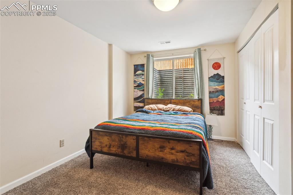 Image 24 of 35: Carpeted bedroom with baseboards and visible vents