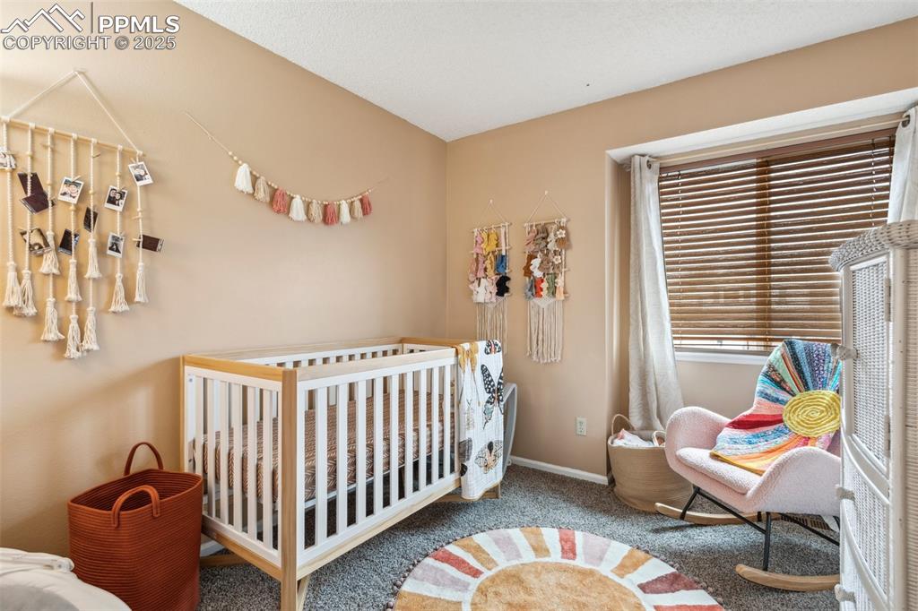 Image 26 of 35: Bedroom featuring baseboards, carpet, and a nursery area