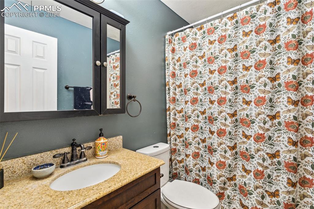 Image 28 of 35: Bathroom featuring vanity, a shower with shower curtain, and toilet