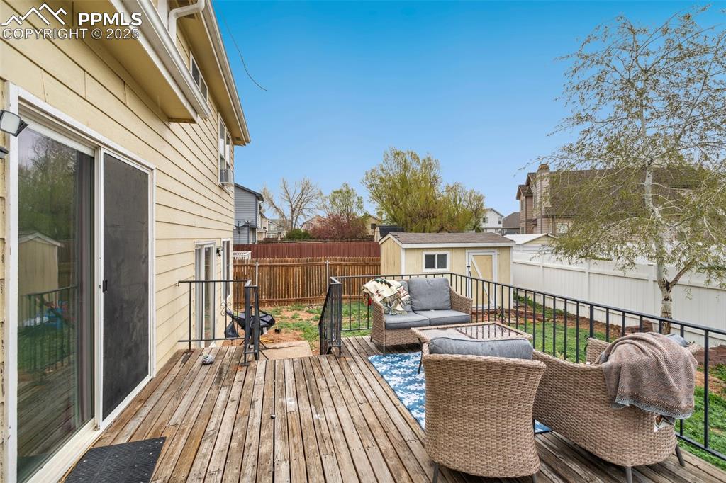Image 33 of 35: Deck with a fenced backyard, an outdoor structure, an outdoor living space,