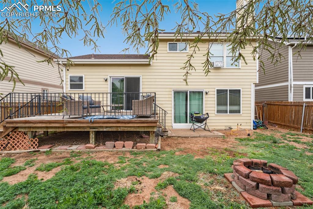 Image 35 of 35: Rear view of property featuring a fenced backyard, a yard, an outdoor fire