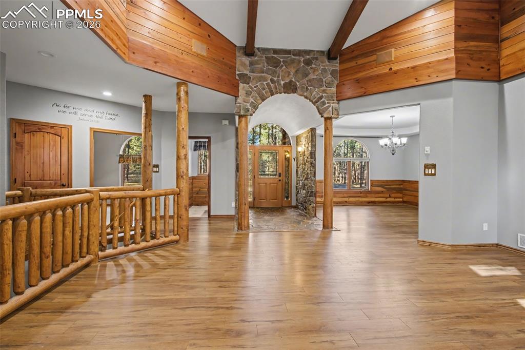 Image 13 of 50: Entrance foyer featuring ornate columns, light wood-style floors, suspended