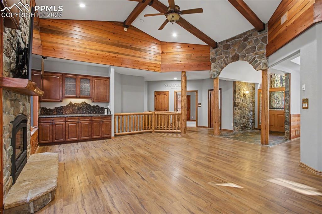 Image 14 of 50: Unfurnished living room with a stone fireplace, light wood-style flooring, 