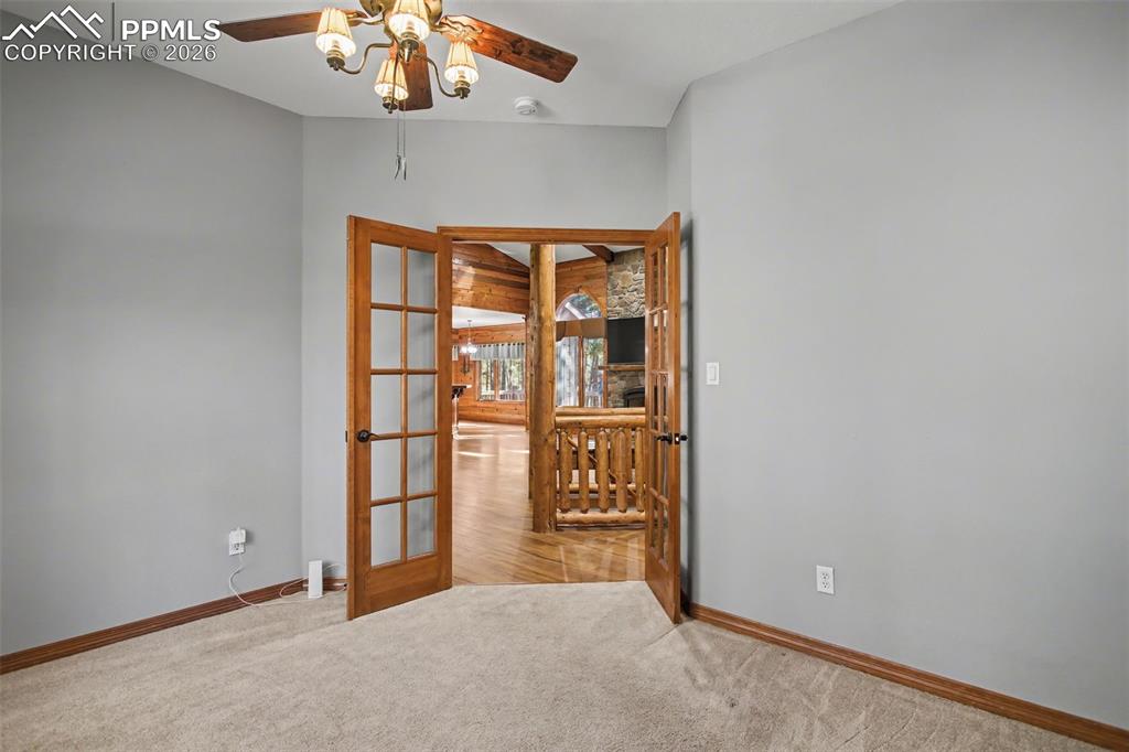 Image 21 of 50: Empty room featuring french doors, ceiling fan, and light carpet