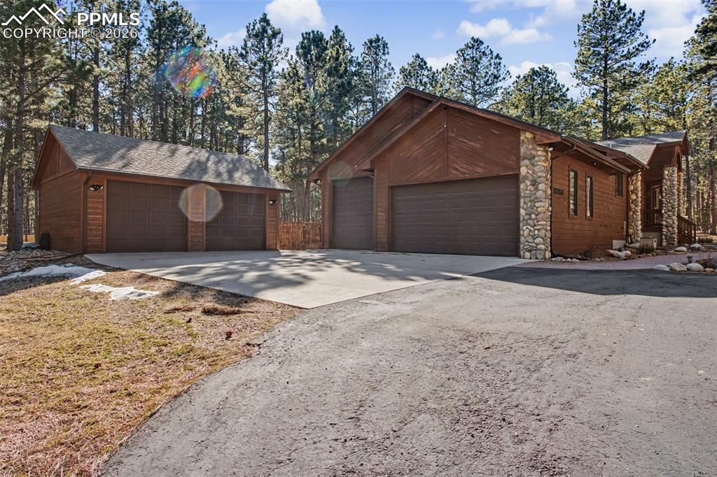 Image 5 of 50: View of front of property featuring stone siding and concrete driveway