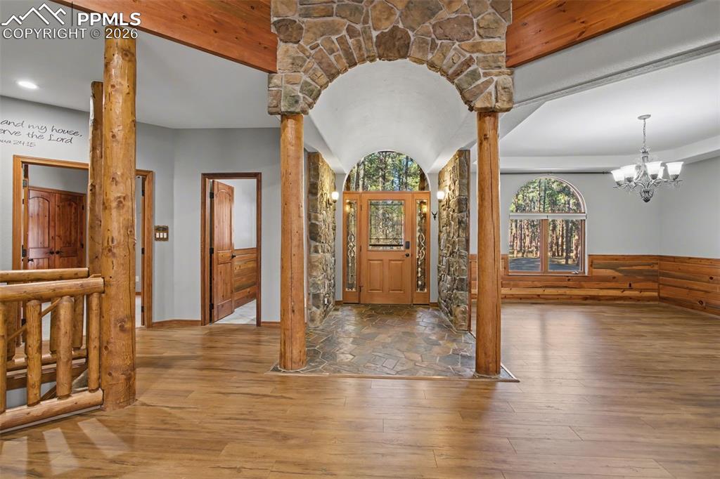 Image 9 of 50: Entryway featuring hardwood / wood-style floors, ornate columns, a chandeli
