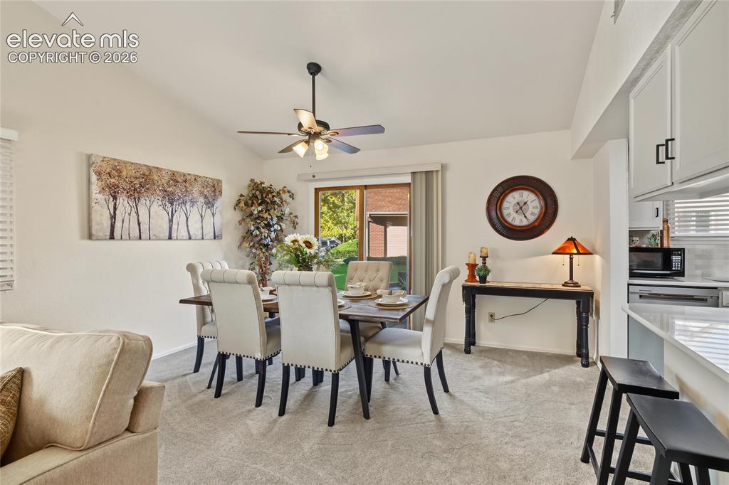 Image 11 of 27: Vaulted ceiling, ceiling fan, sliding glass door, carpet flooring, white ca