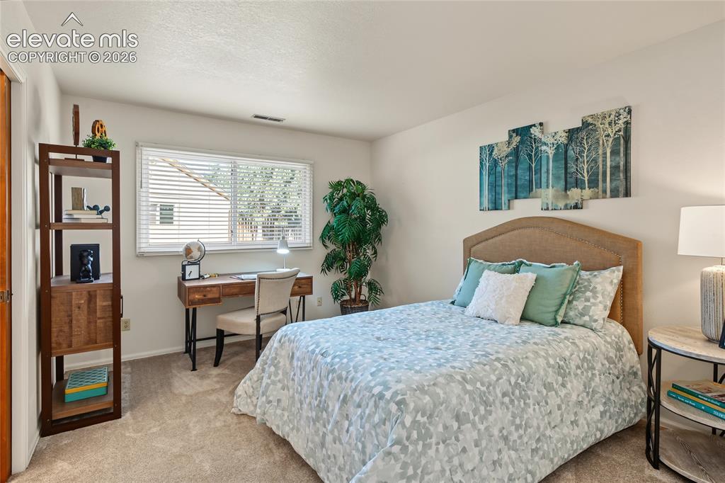 Image 15 of 27: Carpeted flooring throughout with a single window featuring horizontal blin