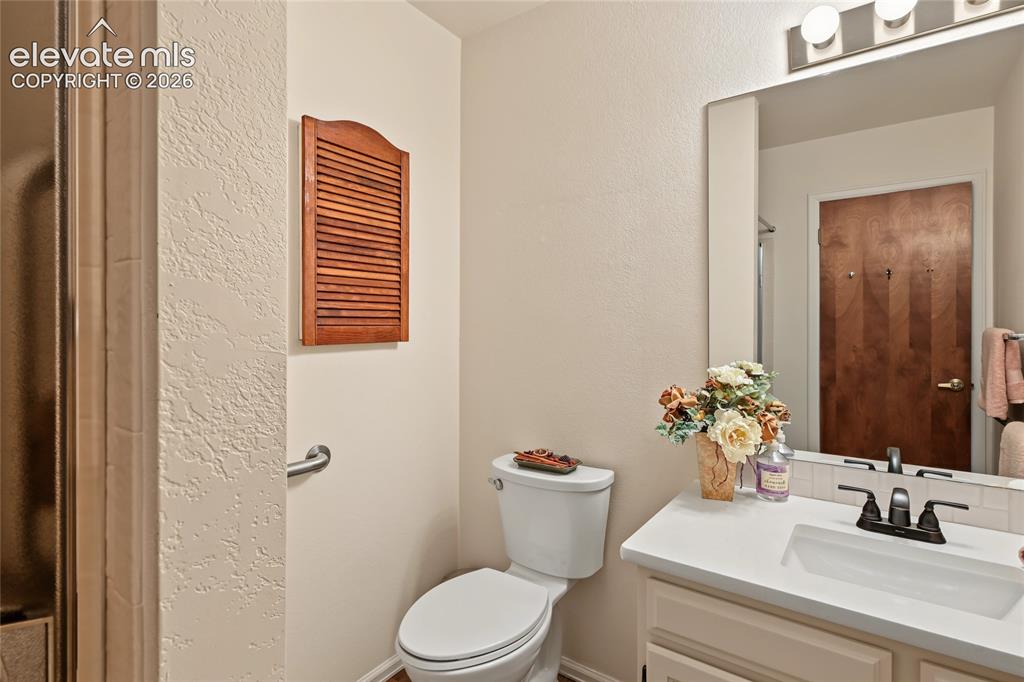 Image 22 of 27: White vanity with an integrated sink and bronze-finish faucet