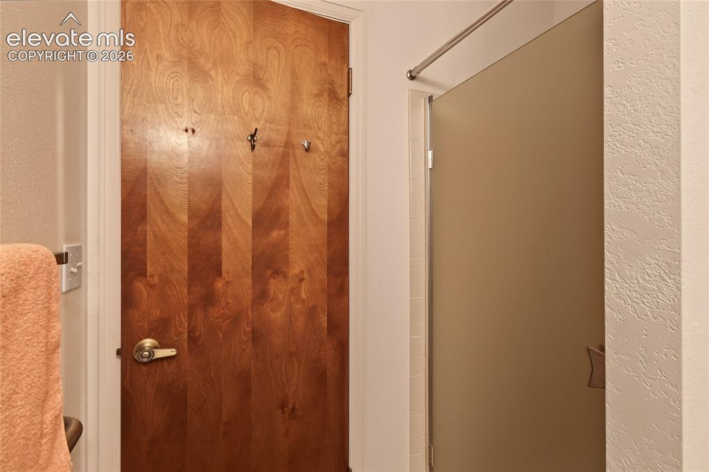 Image 23 of 27: Wood-finish door with a brass-finish handle