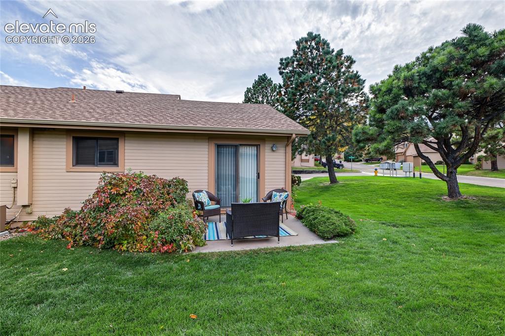 Image 24 of 27: Private patio with direct access, sliding glass door, and surrounding matur