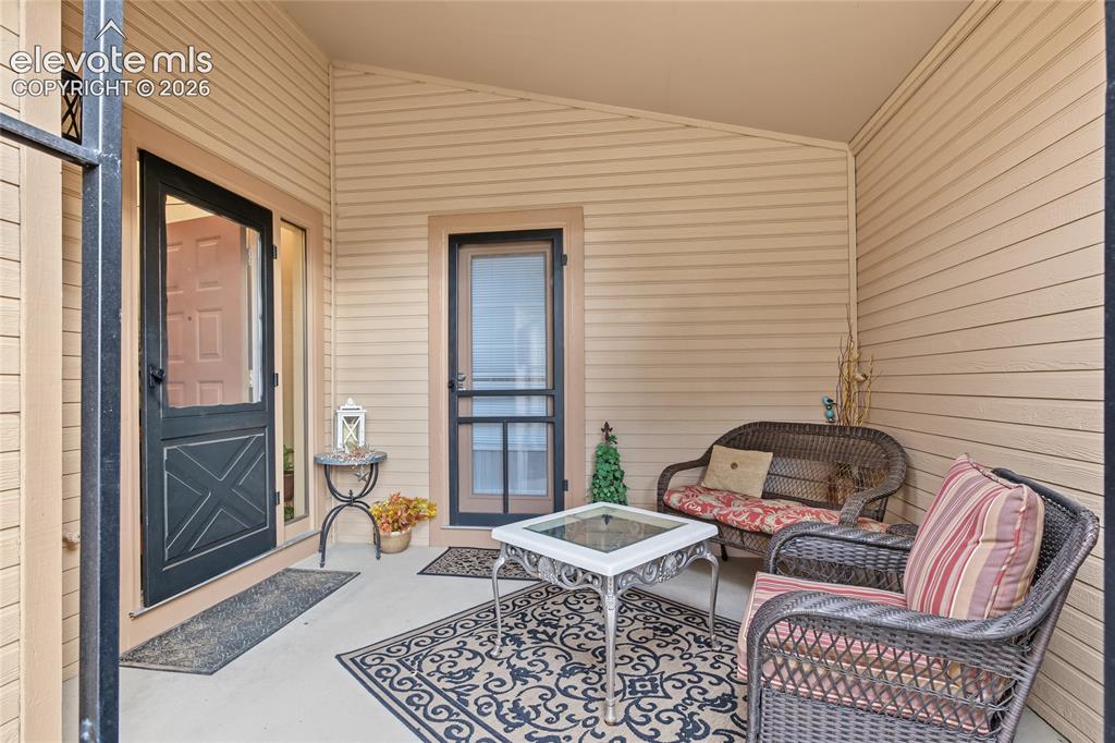 Image 4 of 27: Covered porch featuring durable siding, a solid entry door with a storm doo