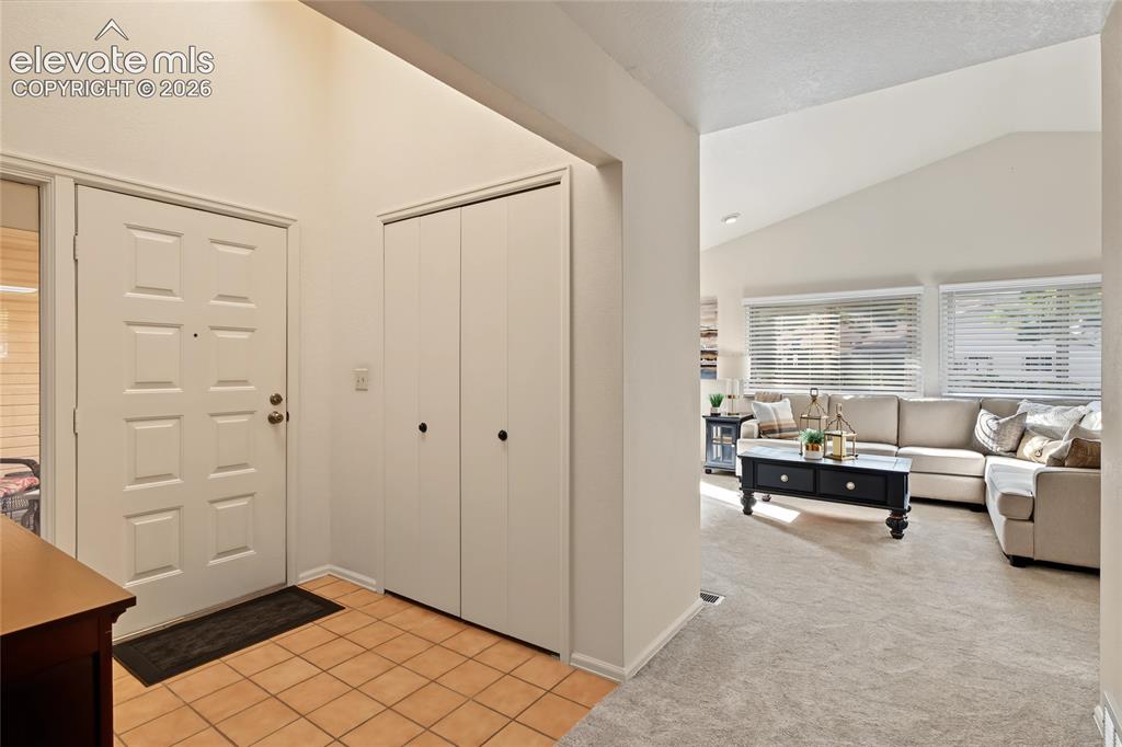 Image 6 of 27: Entry with tiled flooring and a paneled front door