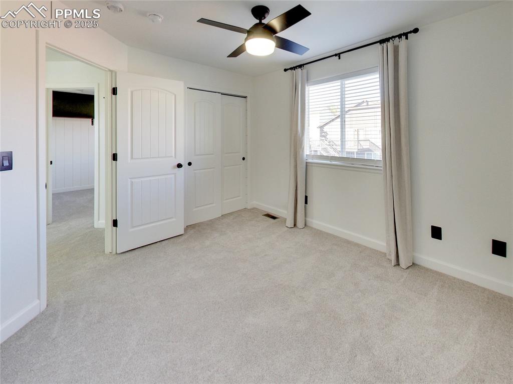 Image 25 of 37: Unfurnished bedroom with light carpet, a ceiling fan, and a closet