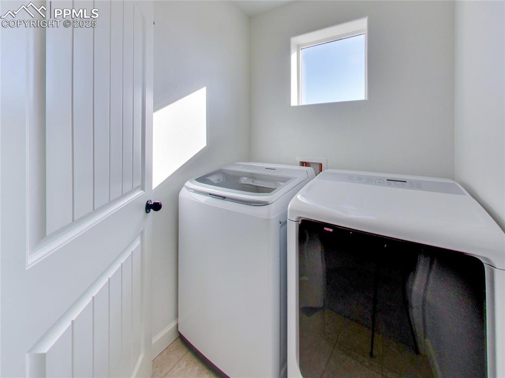 Image 27 of 37: Washroom with washer and clothes dryer and light tile patterned flooring