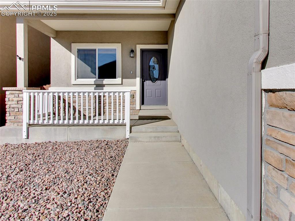 Image 3 of 37: Property entrance featuring covered porch and stucco siding