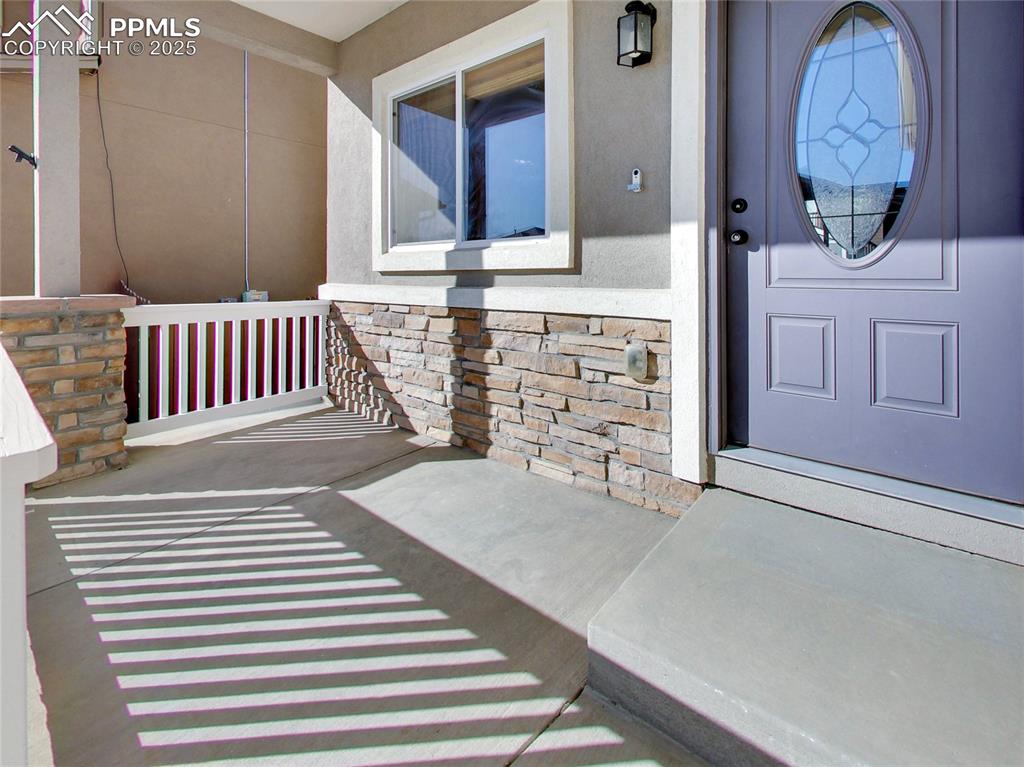 Image 4 of 37: Property entrance featuring stone siding and stucco siding