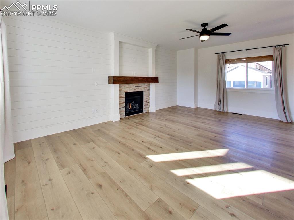 Image 5 of 37: Unfurnished living room with a fireplace, light wood-type flooring, a ceili