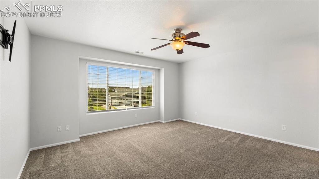 Image 21 of 46: Carpeted spare room featuring a ceiling fan and baseboards