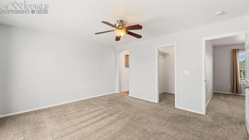 Image 22 of 46: Unfurnished bedroom with carpet flooring, a spacious closet, a ceiling fan,