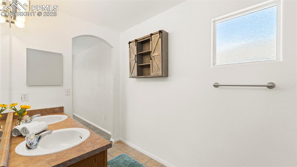 Image 24 of 46: Bathroom featuring double vanity and baseboards