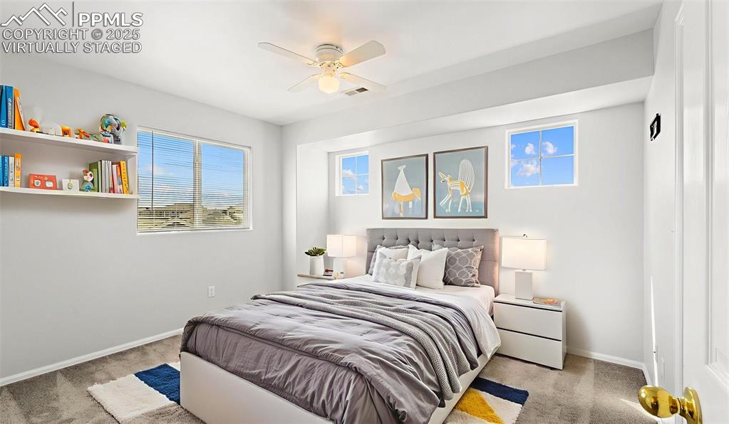 Image 26 of 46: Bedroom with light carpet, multiple windows, and ceiling fan - Virtually St