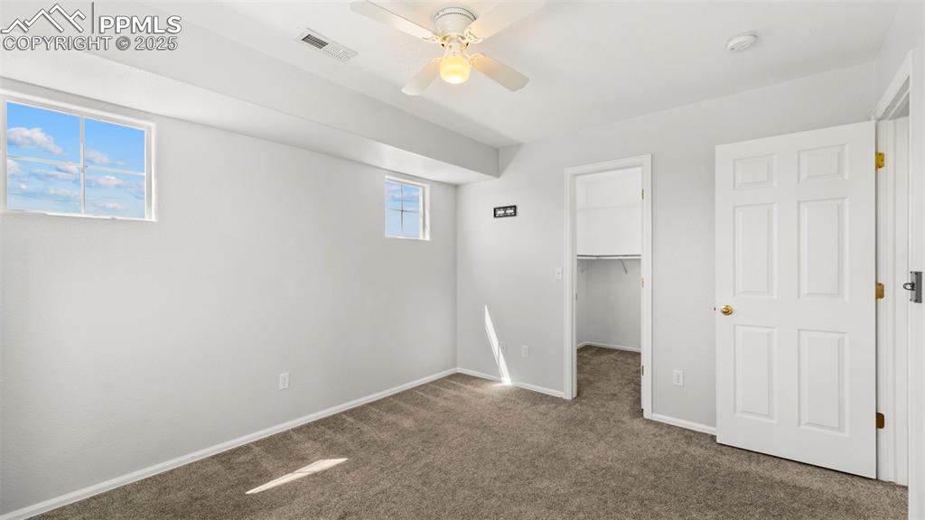 Image 28 of 46: Unfurnished bedroom featuring carpet flooring, a walk in closet, and a ceil