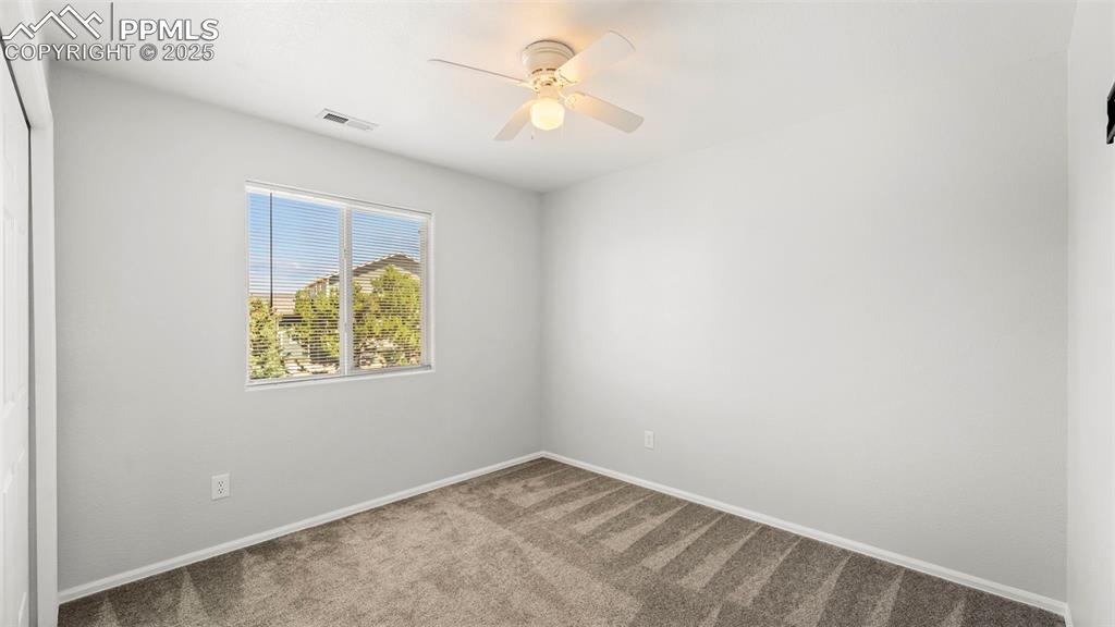 Image 32 of 46: Carpeted spare room with a ceiling fan and baseboards